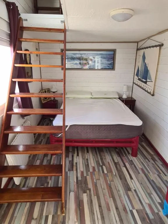 Chambre avec escalier en bois à La Chaloupe